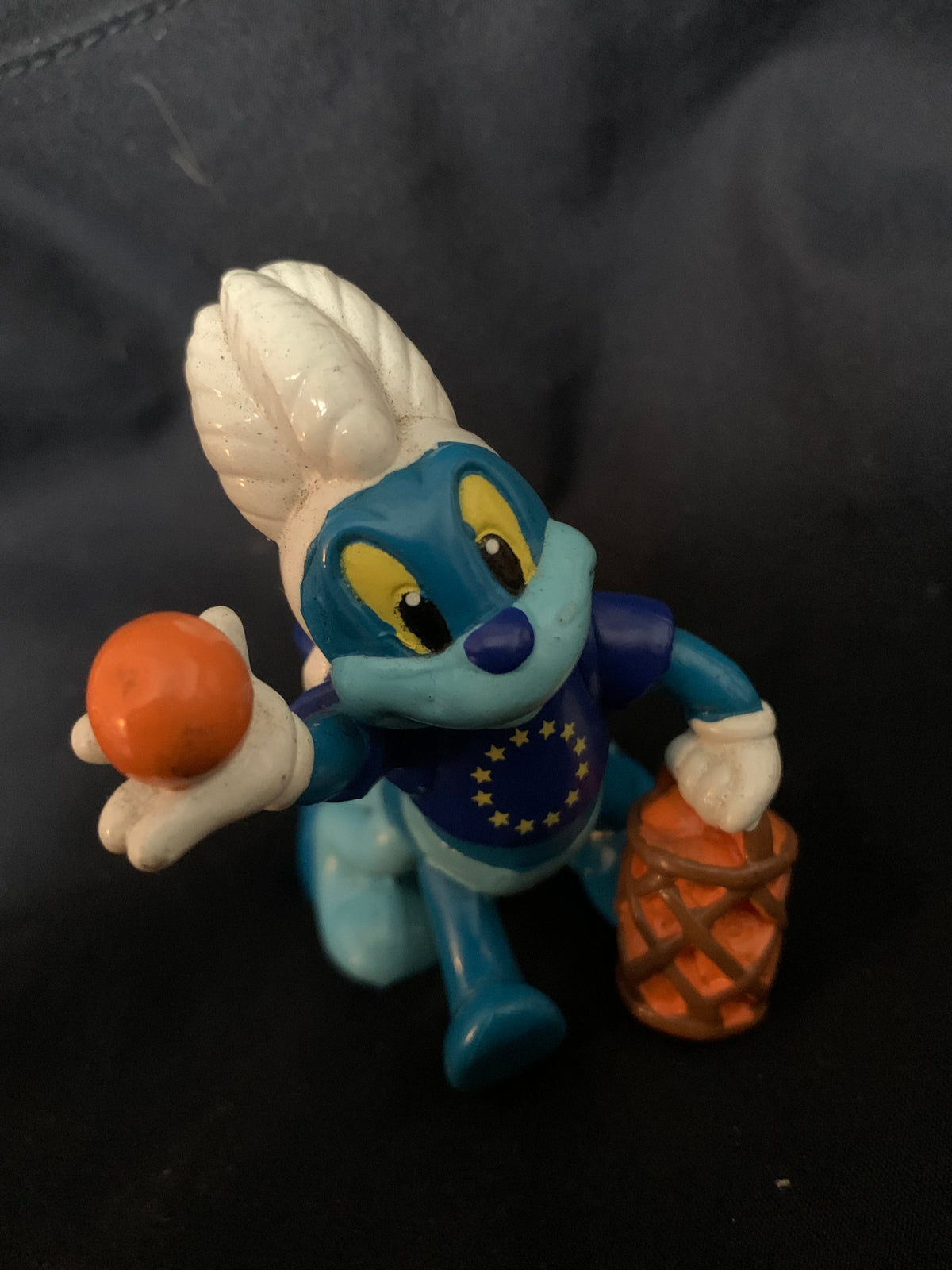 Blue and white smurf figurine wearing european union vest holding orange basketball and basket toys 001
