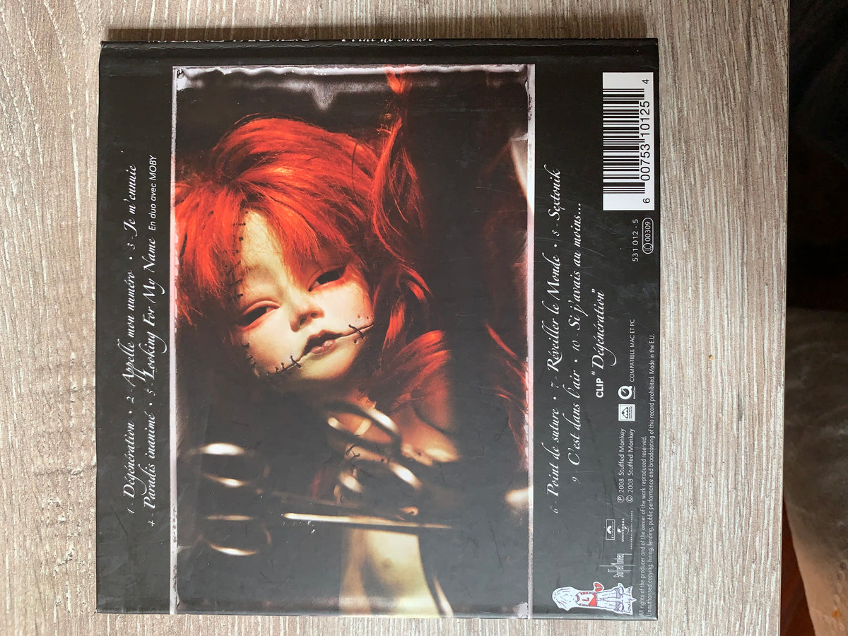 Black cd case cd 001 featuring a haunting doll with red hair and stitched face on a dark background