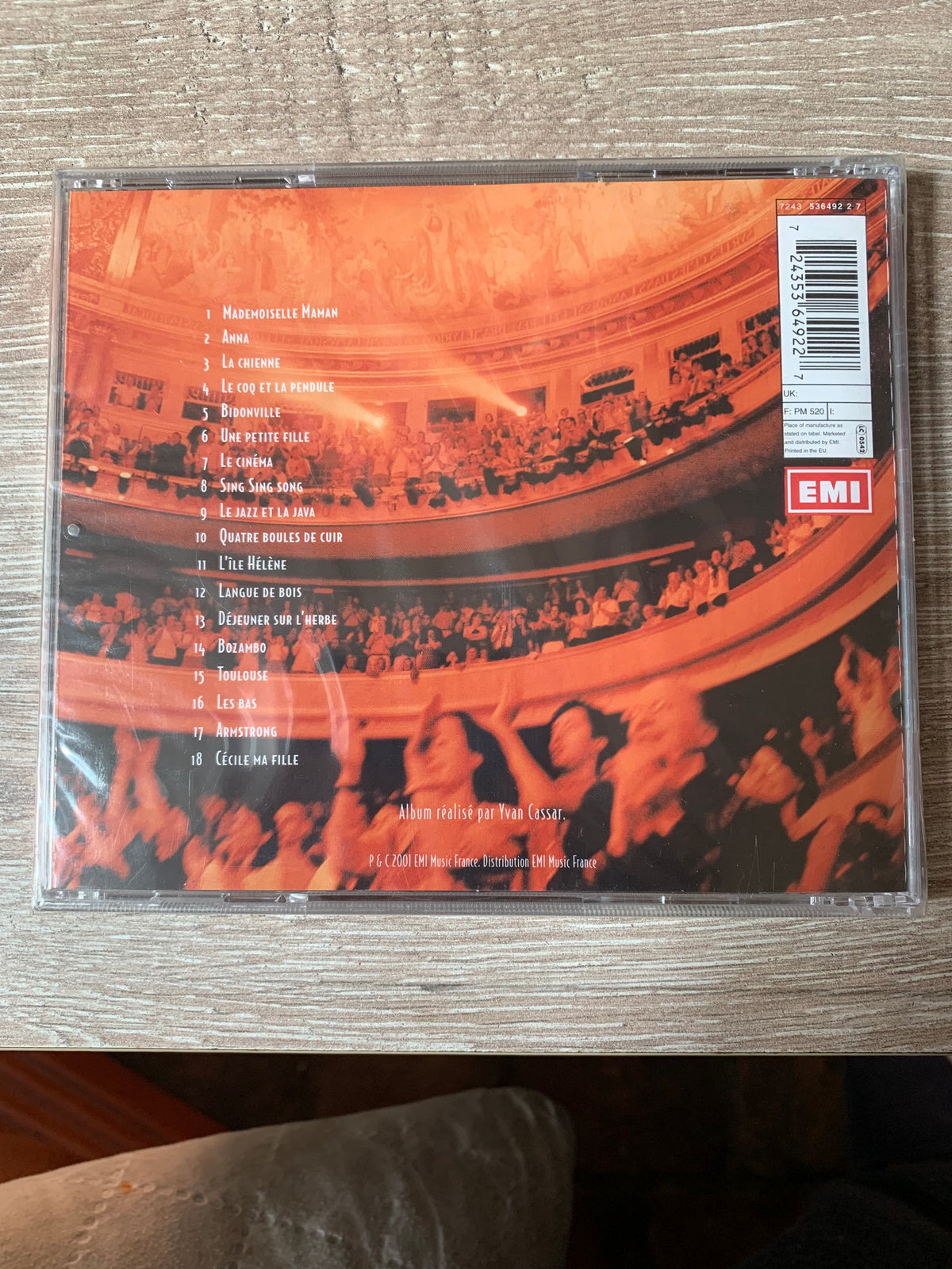 Back side of an orange cd case cd 001 featuring a photograph of an orchestra and audience with the emi logo in red