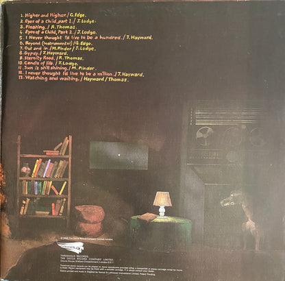 Darkly lit album cover for the moody blues to our childrens childrens children featuring vintage radio and giraffe figurine