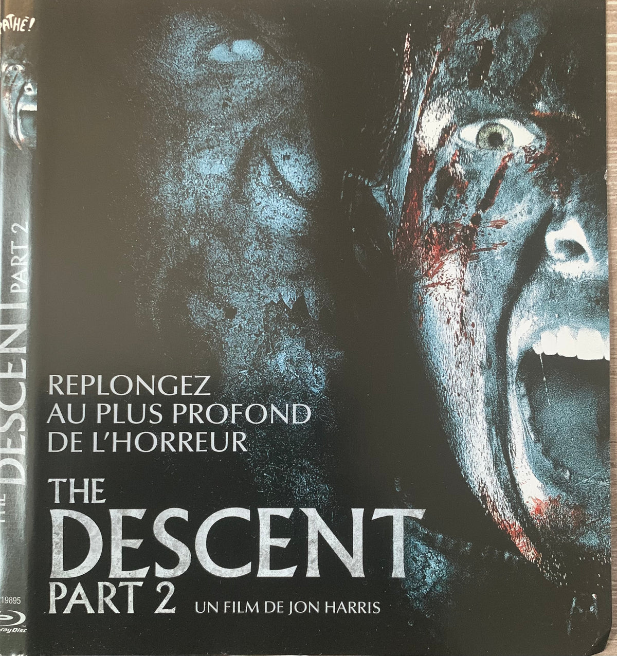The descent part 2 blu-ray steelbook with a dark gritty cover featuring two distorted faces in blue and black tones