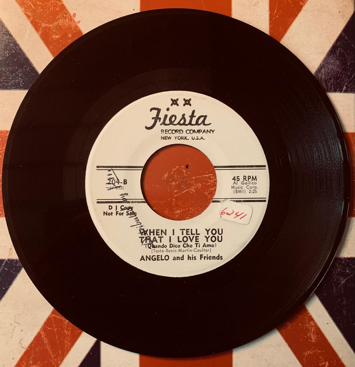 Black vinyl record with white label and orange center from fiesta featuring angelo and his friends original 45t vinyl