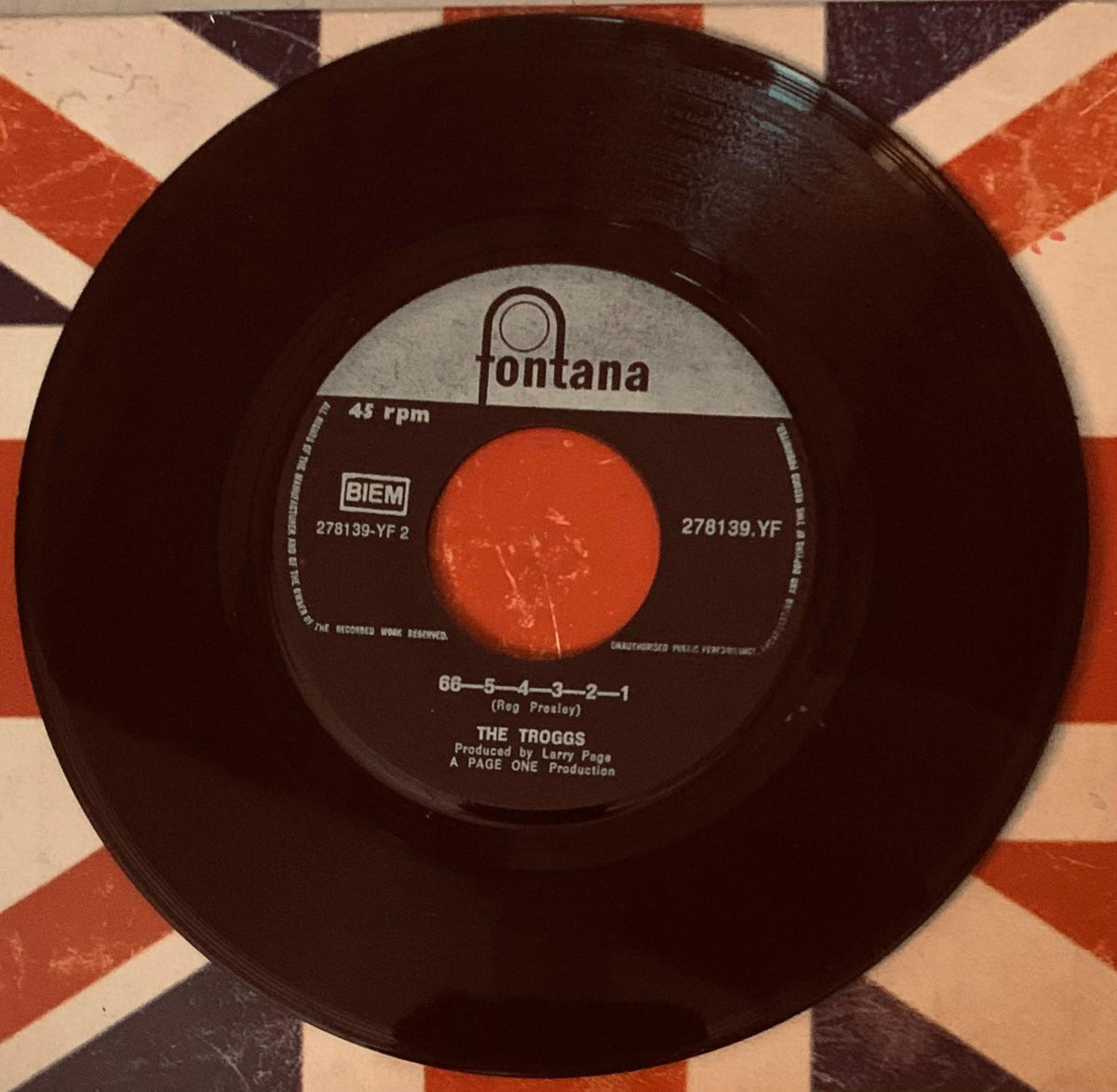 Black vinyl 45 rpm record with white fontana label and orange center hole featuring the troggs and a page one production text