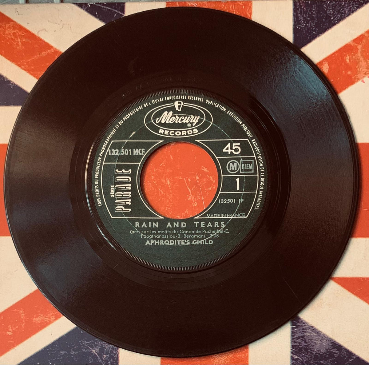 Black vinyl 45 rpm record by Aphrodite’s Child with green label and mercury records branding for rain and tears single