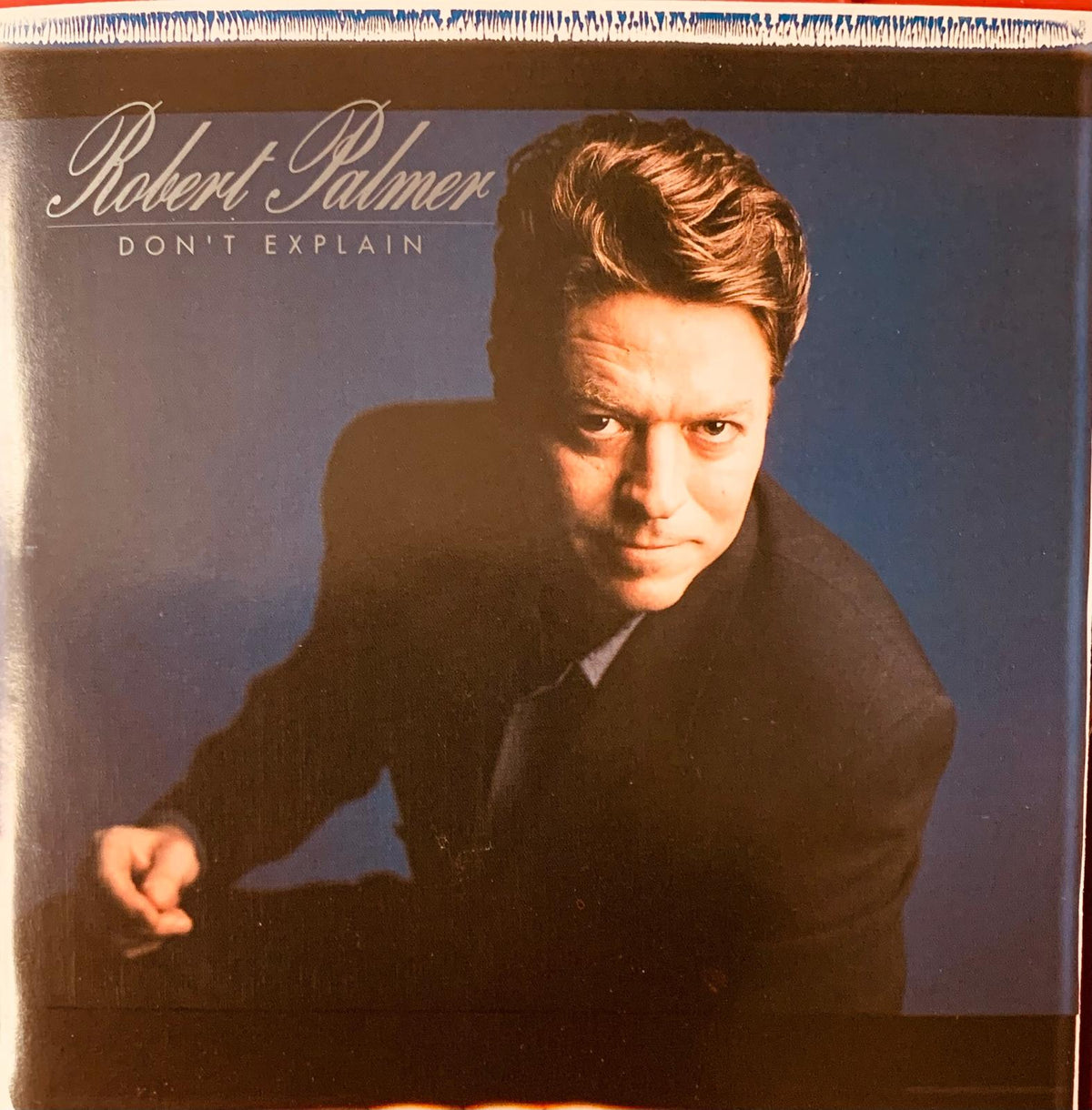 Robert Palmer dont explain original CD album cover featuring the artist in dark formal attire on a deep blue background
