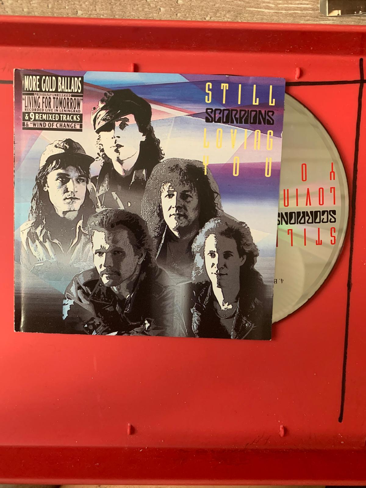 Cd album still loving you by scorpions with black and white band photo and bold yellow and blue text on cover