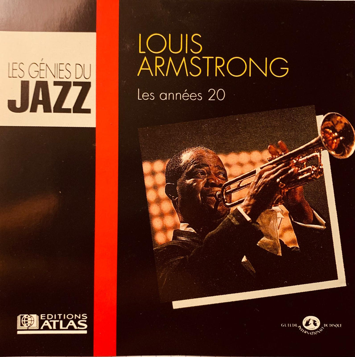 Black vinyl record album cover featuring louis armstrong playing trumpet with gold lettering and red vertical stripe
