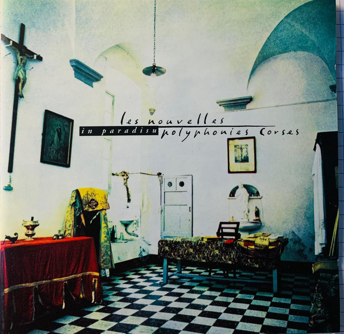 Album cover for Les Nouvelles Polyphonies Corses in Paradisu CD showing a dimly lit room with arched ceilings and checkered floor
