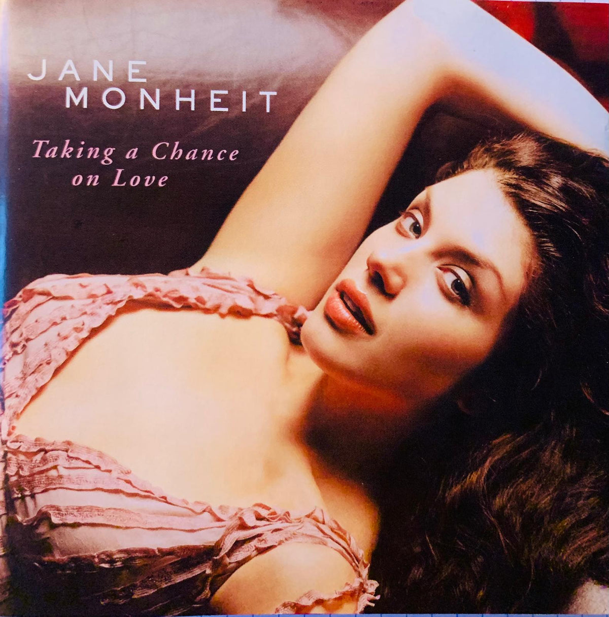 Jane Monheit original CD album cover for Taking A Chance On Love features the artist in a soft pink ruffled lace top