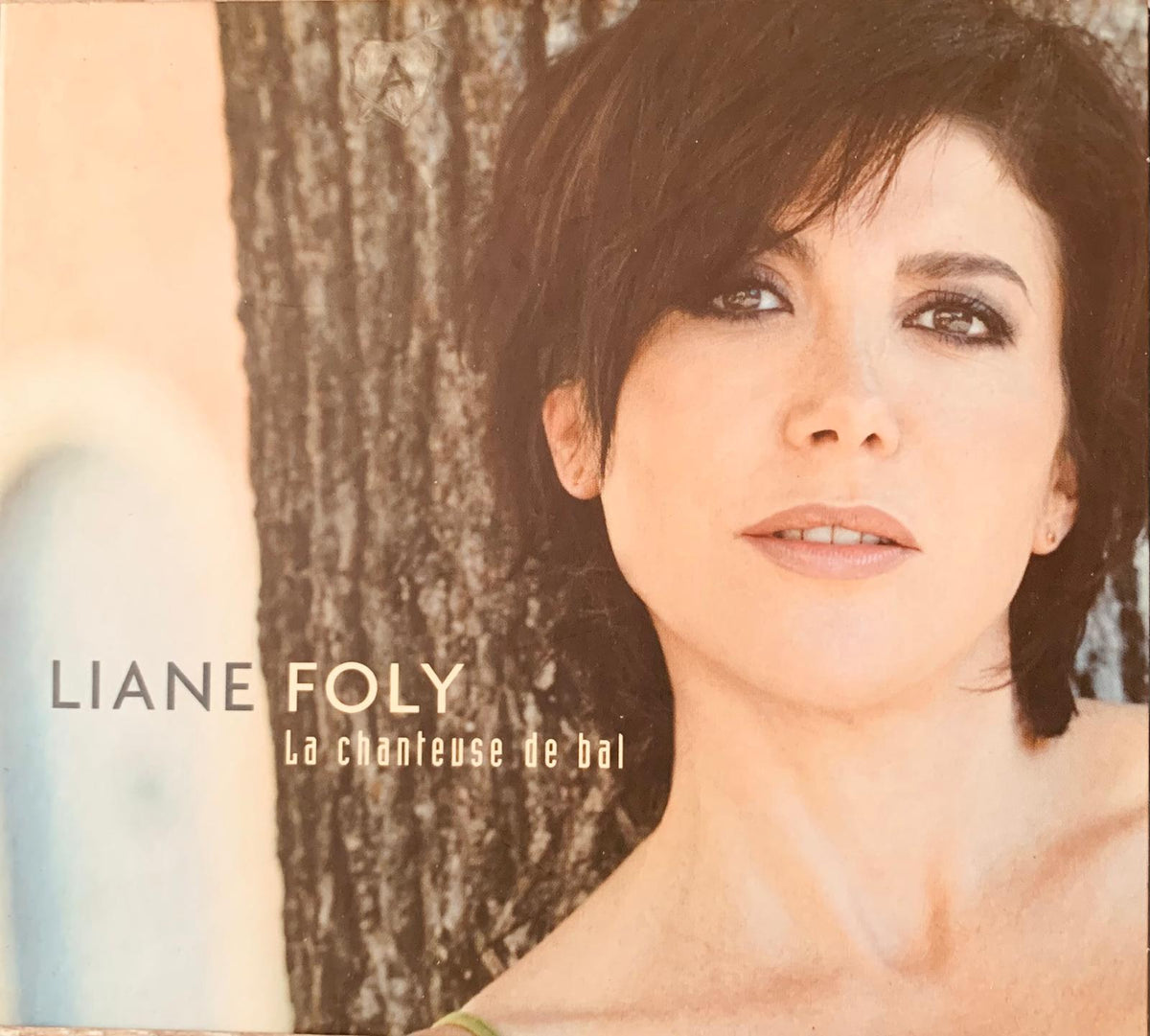 Liane Foly album cover for La Chanteuse De Oui original CD featuring warm-toned portrait with tree trunk background