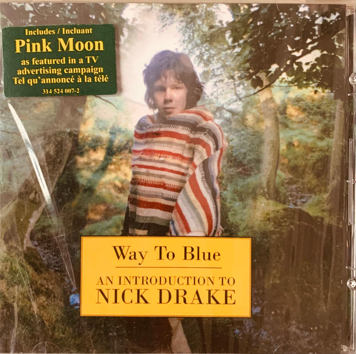 The album cover for nick drakes way to blue cd features a young man in a red white and gray striped knitted sweater