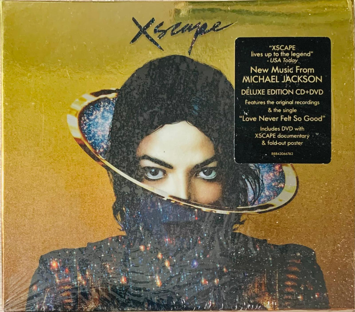 Gold-colored deluxe edition cd and dvd case for michael jackson xscape album with cosmic stars and galaxy ring design