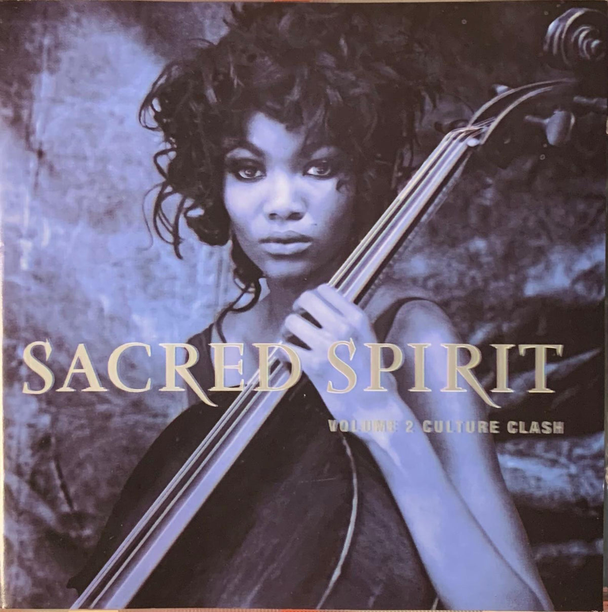 Blue-toned album cover of sacred spirit volume 2 featuring a woman with curly hair holding a cello