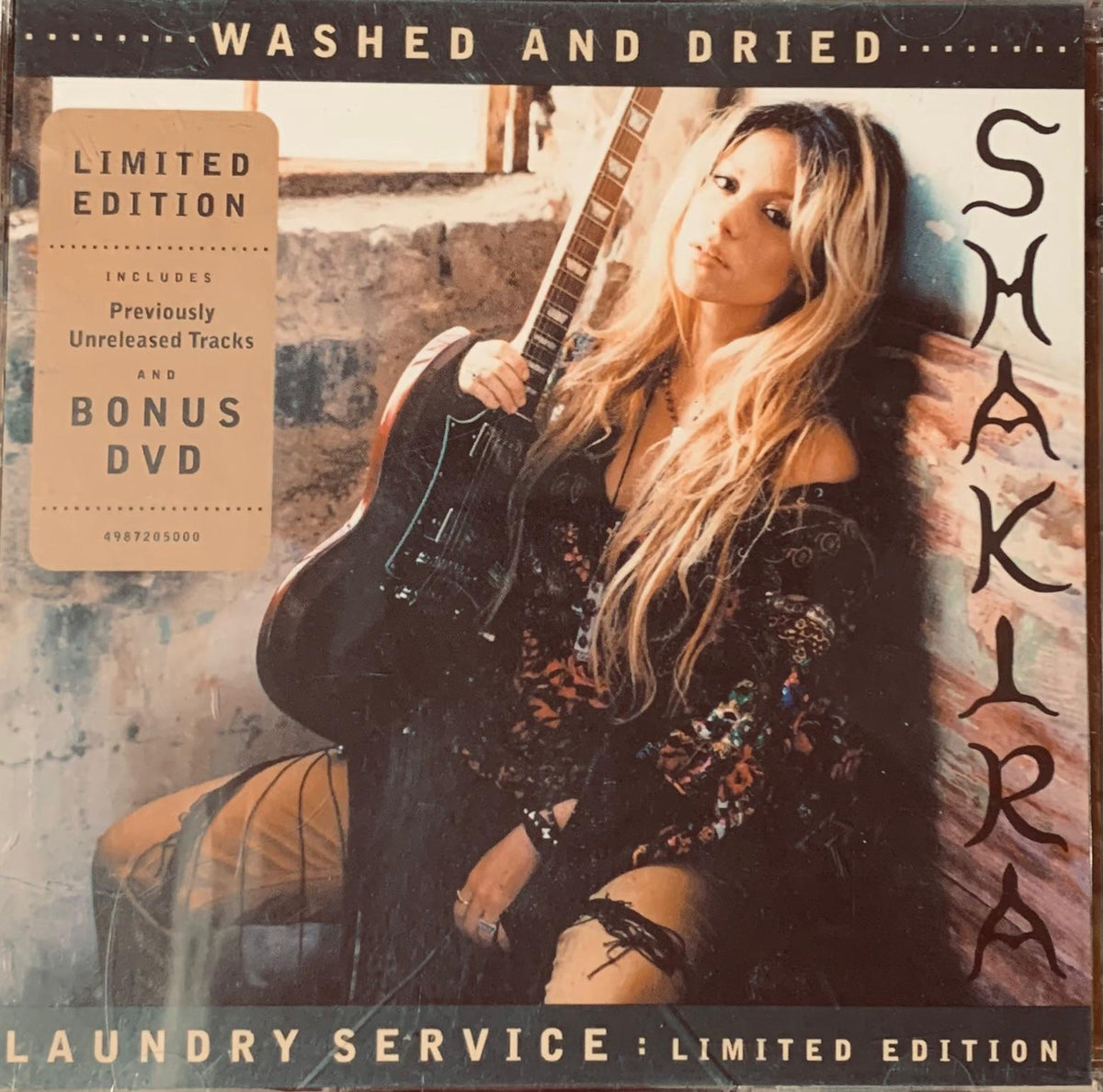 Limited edition black vinyl record album cover featuring Shakira in dark patterned outfit holding electric guitar for Laundry Service