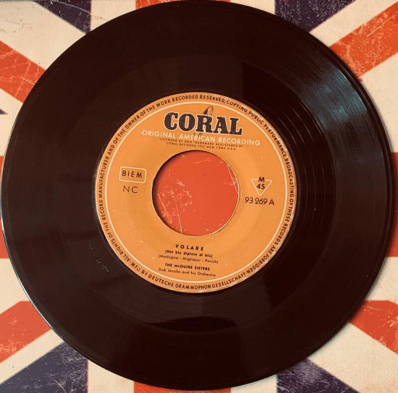 Black vinyl record with orange coral records label featuring volare by the mcguire sisters 7 inch german first press