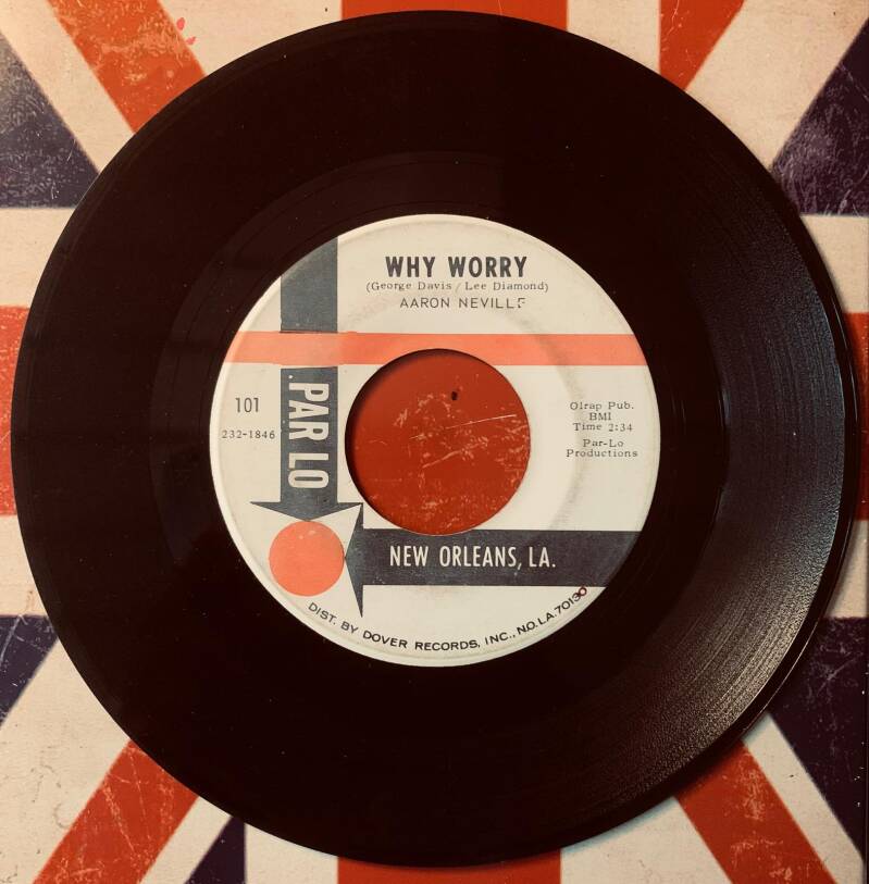 Black vinyl 7 inch record with white label featuring orange gray stripes of aaron neville why worry from 1966 par lo soul