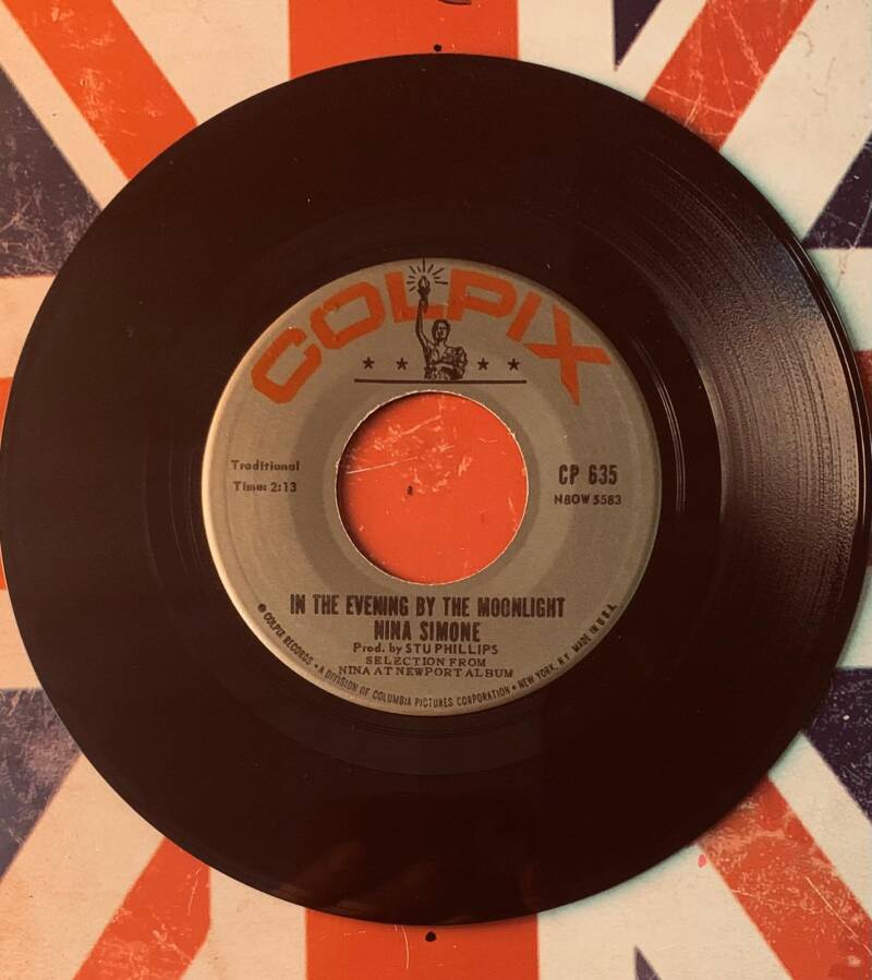 Black vinyl record with silver and orange colpix label featuring nina simone song in the evening by the moonlight