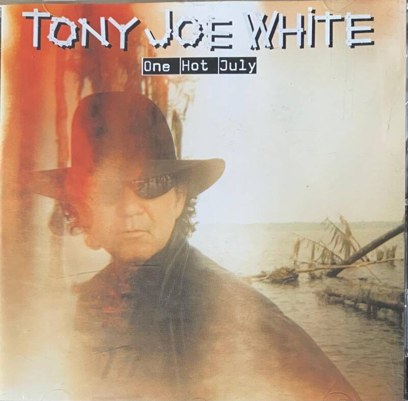 Tony Joe White One Hot July CD cover featuring a man in a dark hat and sunglasses against warm water tones