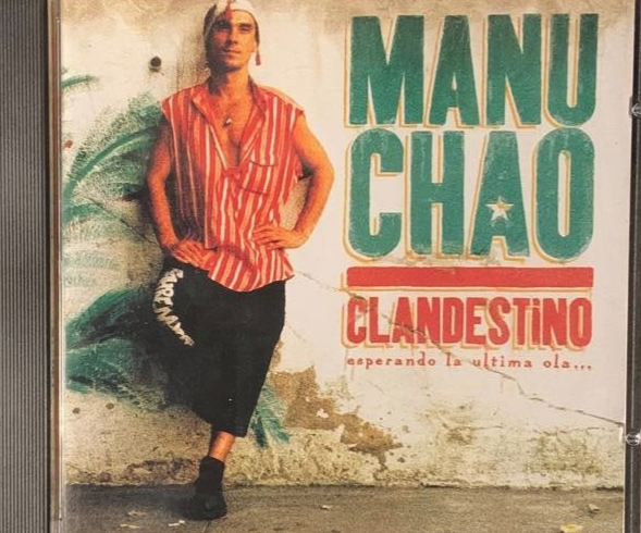 Manu Chao clandestino CD 1998 featuring a man in a red and white striped shirt against a weathered wall backdrop