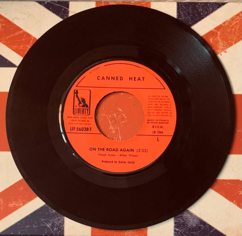 Black vinyl record with vibrant orange label featuring canned heat on the road again from 1968 liberty french first press