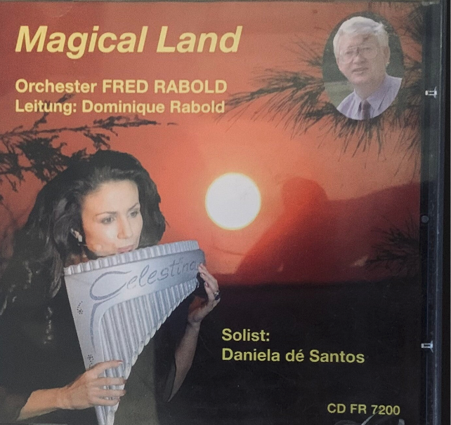 A silver-colored metallic pan flute with flared design and engraved lettering in orchester fred rabold magical land cd