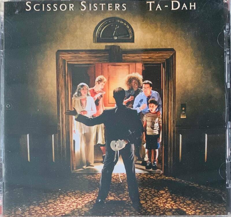 The album cover of Scissor Sisters ta-dah CD features a painted scene with dramatic lighting and an elevator door