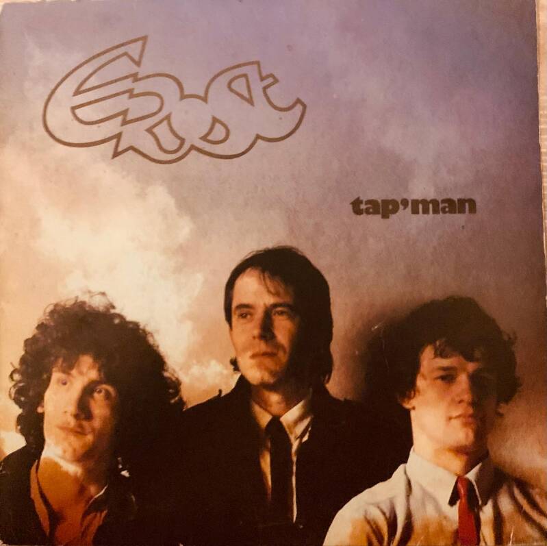 The album cover for tap man by east features a vintage design with three men against a cloudy sky backdrop